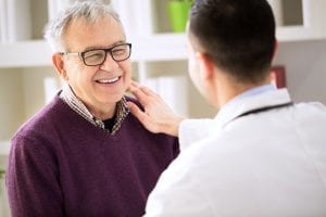 doctor with older male patient smiling